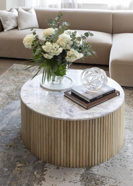 Coffee table with flowers, books and ornament on top