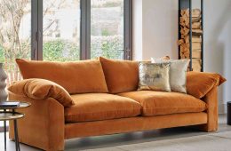 Large orange fabric sofa in a neutral toned room
